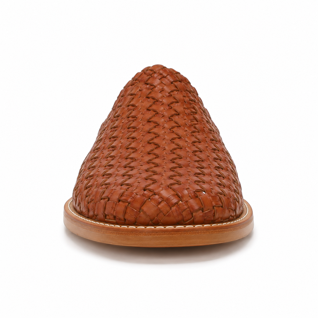 Side profile of men's cognac hand-woven vegan leather mule showing the woven upper and natural tan leather sole