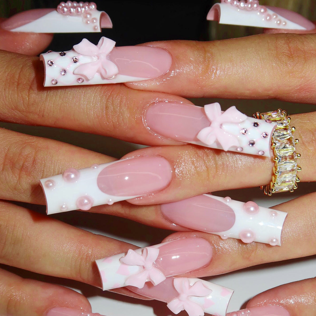 Artistic acrylic nails with bow and pearl decorations
