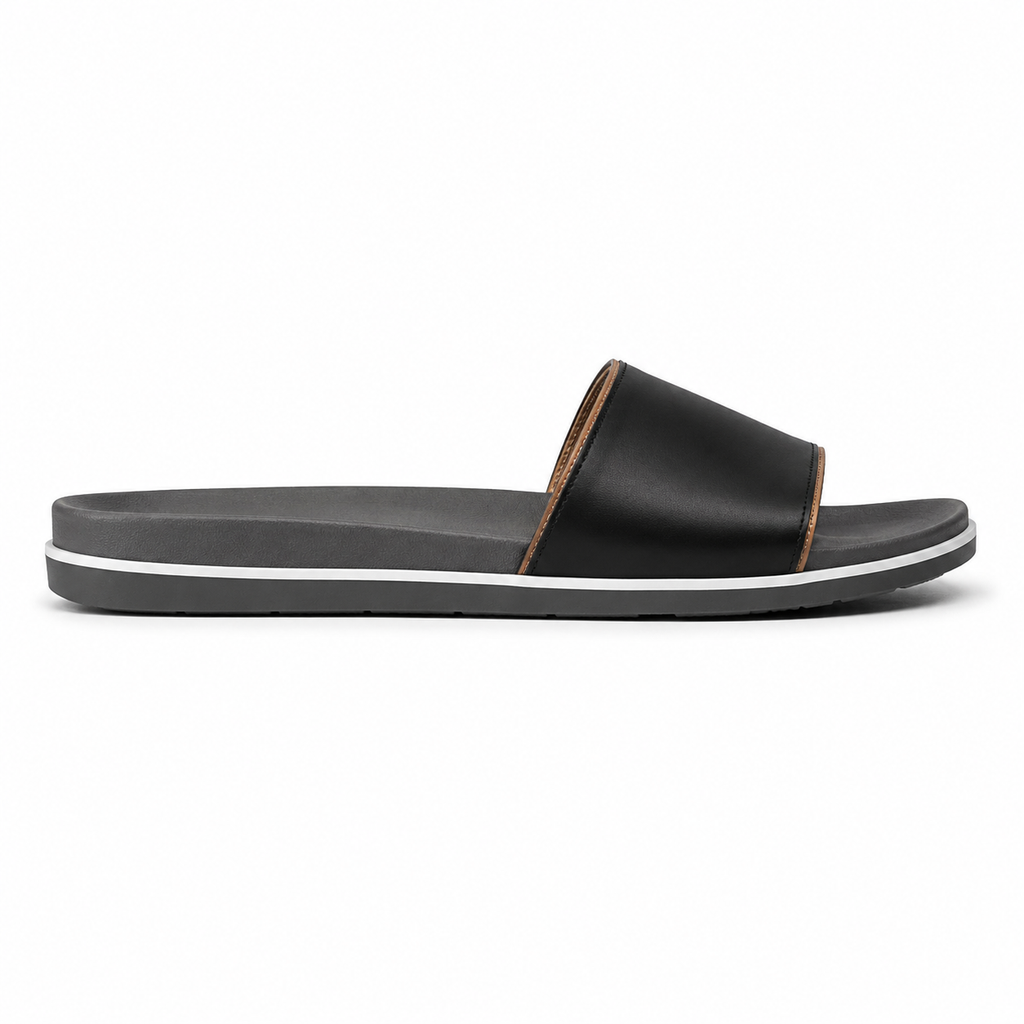 Front view of women's black single-band vegan leather slide sandal showing the contoured grey footbed and warm tan piping