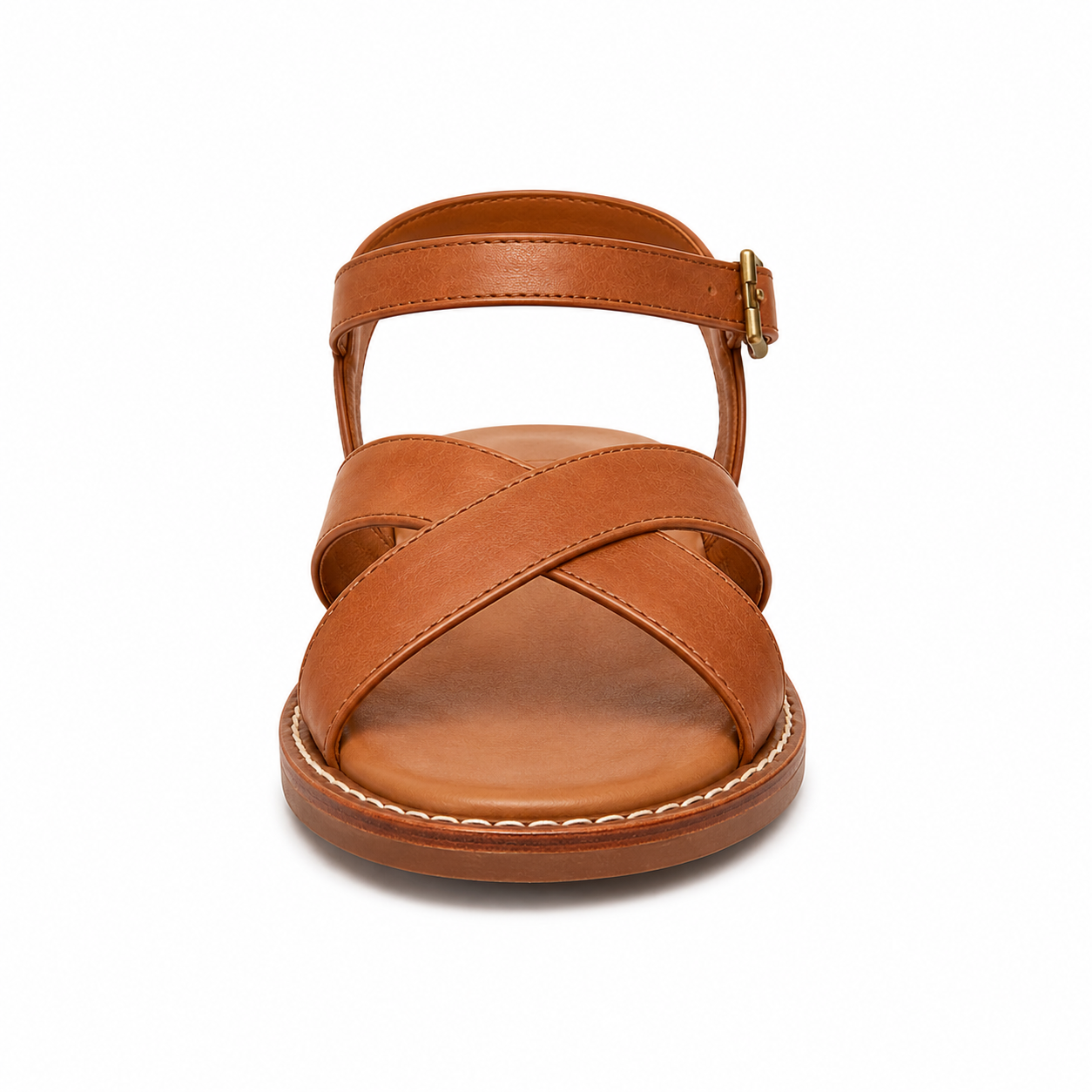 Side profile of women's caramel cross-strap vegan leather sandal showing the antique brass ankle buckle and slim welted sole