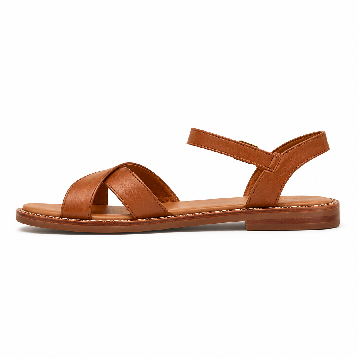 Women's cross-strap vegan leather sandal in caramel with antique brass ankle buckle and stitched leather welt sole, three-quarter view