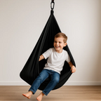 Therapist supervising child in blue sensory swing during occupational therapy session.