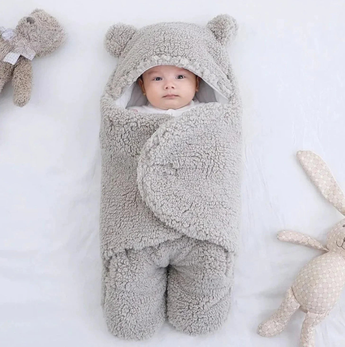 Baby sleeping peacefully in white BONEROSHOP sleeping bag, demonstrating comfort for naps at home.