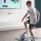 Young footballer wearing anti-slip socks training with ball on Football Pro Training Mat