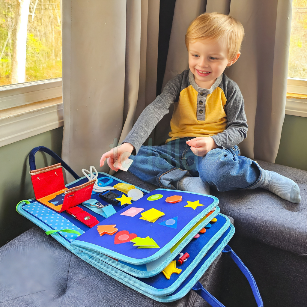 Toddler using Montessori busy board with zips, buttons and buckles for fine motor skill development