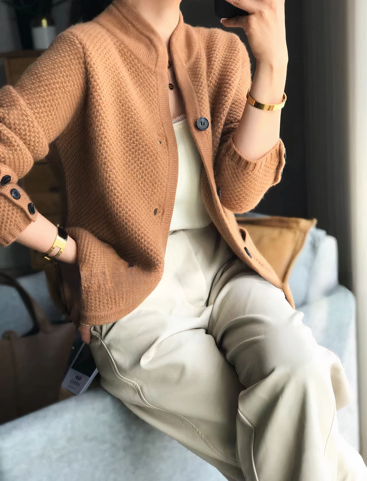 Close-up detail of the luxurious 100% cashmere fabric and button fastening on the women's cardigan