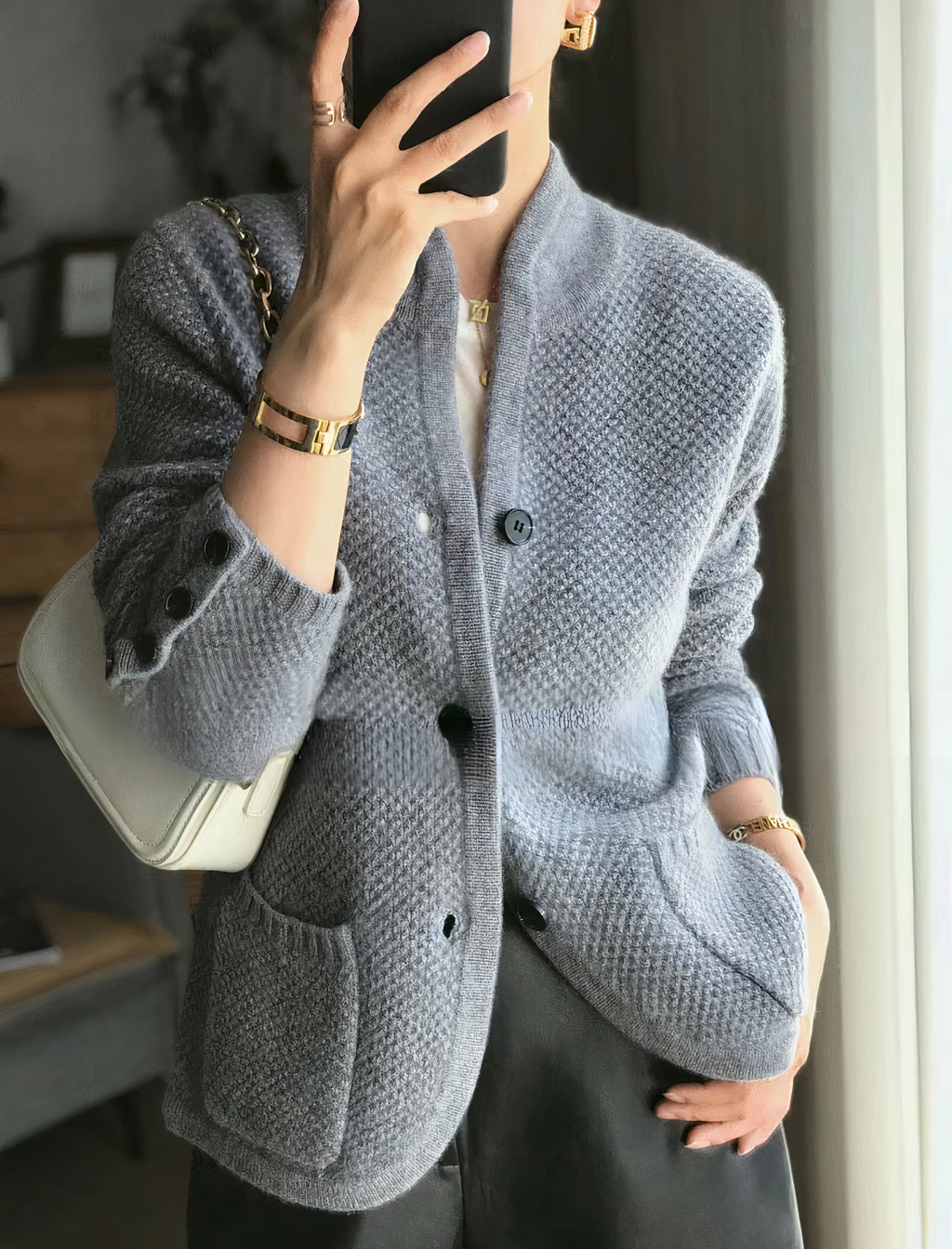 Woman wearing the cashmere button-up cardigan layered over a blouse for versatile styling
