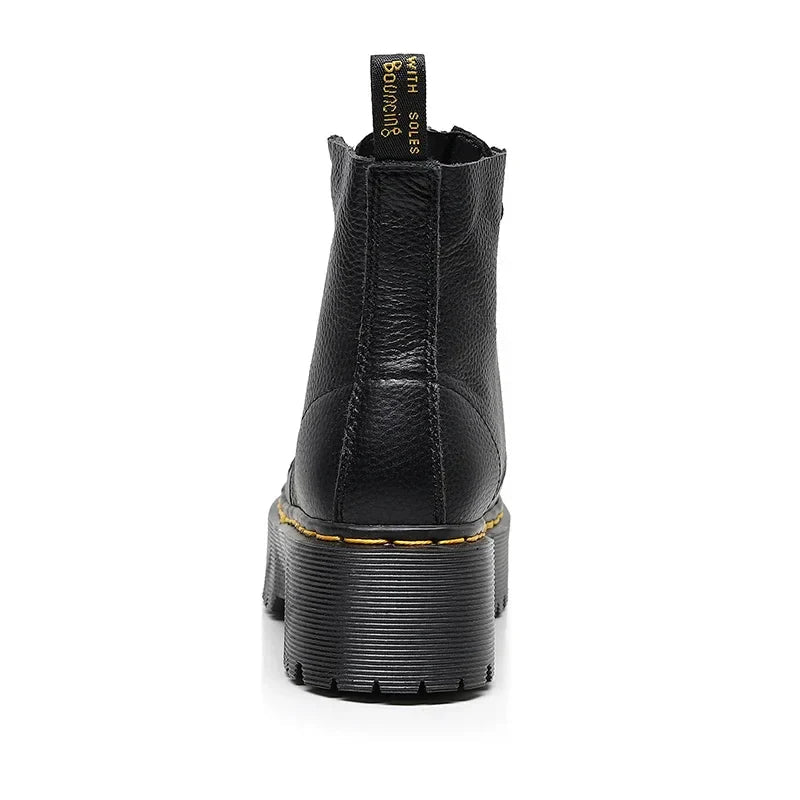 Women's black leather boots with chunky sole, detailed close-up of genuine leather material and durable sole construction.